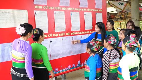 Cử tri các xã miền núi ở Thanh Hóa đến điểm bầu cử theo dõi danh sách người ứng cử đại biểu QH và đại biểu HĐND các cấp