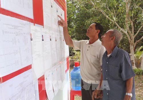 Người dân xã Đất Mũi tìm hiểu danh sách ứng cử viên. Ảnh: Tuấn Phi – TTXVN