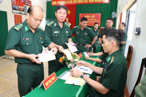 Trung tá Lương Đình Hùng (đứng thứ 2 bên trái), Chính trị viên Đồn Biên phòng Đắk M'Bai nhận phiếu cử tri