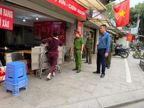 Tổ công tác phường Ô Chợ Dừa nhắc nhở hộ kinh doanh sắp xếp bàn ghế gọn gàng, bảo đảm thông thoáng vỉa hè. Ảnh: Võ Giang