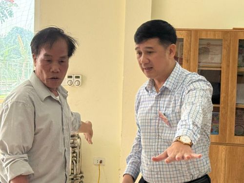 Phó Chủ tịch UBND xã Nguyễn Hữu Minh (phải) trao đổi với trưởng thôn 5 Nguyễn Văn Năm về những phần việc cần hoàn tất trong ngày cuối trước bầu cử.