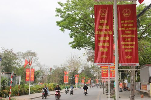 Sắc đỏ của cờ Tổ quốc và băng rôn tuyên truyền được treo rực rỡ dọc các tuyến đường trung tâm phường Định Công, tạo nên không khí trang trọng trước ngày hội bầu cử.