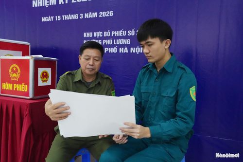 Hai thế hệ - ông Vũ Bá Bình và em Bùi Thế Đạt trao đổi về danh sách cử tri.