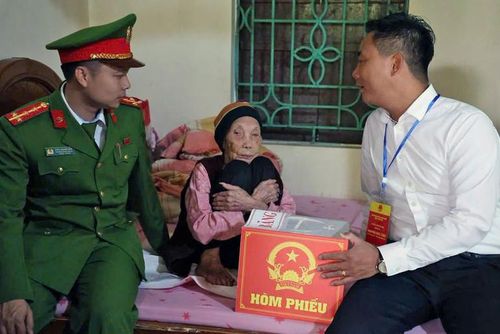  Đồng chí Nguyễn Đức Tiến (bên phải) cùng đại diện các lực lượng chức năng đến thăm hỏi, động viên, hỗ trợ cụ Tính thực hiện quyền công dân. 