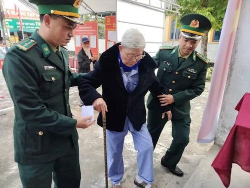 Cán bộ đồn Biên phòng Diễn Thành hỗ trợ cử tri đi bầu cử.