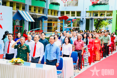 Các đại biểu làm lễ chào cờ tại khu vực bỏ phiếu. 