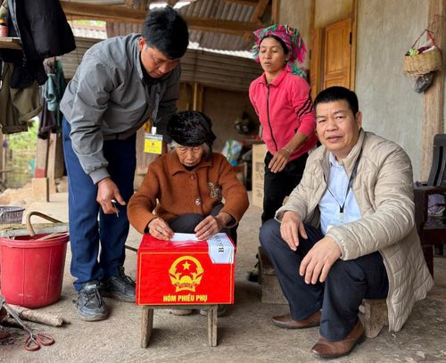 Cán bộ xã Sín Thầu mang hòm phiếu lưu động tới tận nhà những người già yếu để họ thực hiện quyền bầu cử. Ảnh: ĐỖ GIANG