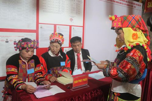 Cử tri nhận phiếu bầu cử. Ảnh: VĂN BÙI