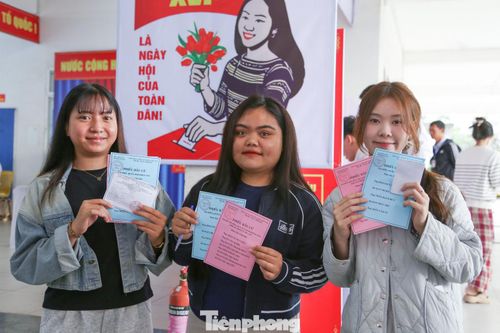 Cầm phiếu cử tri trên tay, bạn Nguyễn Thị Thanh Tâm (sinh viên năm 3 trường ĐH Sư phạm – ĐH Đà Nẵng) được thành viên Tổ bầu cử phát thẻ bỏ phiếu và hướng dẫn bỏ phiếu đúng quy định. Quê ở Hà Tĩnh nên để thuận tiện trong việc bỏ phiếu, trước đó, Tâm (bên phải) đã chủ động thay đổi địa điểm bầu cử trên ứng dụng VNeID theo hướng dẫn của các thầy cô trong ban quản lý ký túc xá. Trước lúc bỏ phiếu, Tâm đọc kỹ lại thông tin các đại biểu một lượt để có sự lựa chọn đúng đắn nhất.