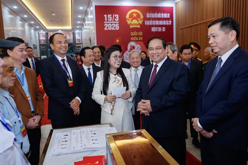 Thủ tướng Phạm Minh Chính và phu nhân trò chuyện với cử tri khu vực bỏ phiếu. Ảnh: Nhật Bắc