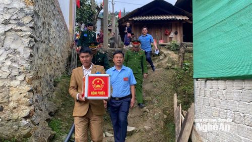 Cán bộ các Tổ bầu cử của xã Nậm Cắn mang hòm phiếu phụ đến từng nhà cử tri cao tuổi, sức khỏe yếu trong sáng 15/3. Ảnh: P.V