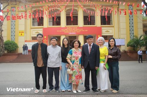 Cụ ông Nguyễn Đức Khiết (94 tuổi) cùng con cháu trong gia đình đến điểm bỏ phiếu số 15 phường Bạch Mai. (Ảnh: Minh Anh/Vietnam+)