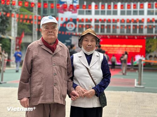 Cụ ông Nguyễn Văn Rừng (95 tuổi) và cụ bà Lê Thị Khiên (83 tuổi) phấn khởi cùng nắm tay nhau đi bộ tới điểm bầu cử. (Ảnh: Thùy Giang/Vietnam+)