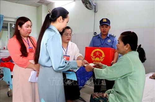 Tổ bầu cử mang thùng phiếu phụ đến tận phòng bệnh tại Bệnh viện Đa khoa Vĩnh Long (phường Phước Hậu). Ảnh: Lê Thúy Hằng/TTXVN