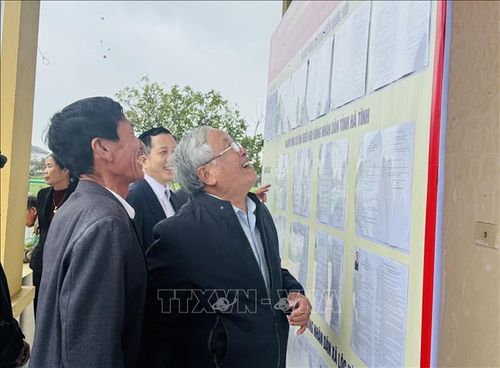 Cử tri xã Lộc Hà theo dõi danh sách đại biểu được niêm yết tại khu vực bỏ phiếu.