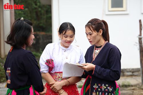 Các nữ cử tri trong trang phục truyền thống cùng trao đổi thông tin về danh sách ứng cử viên trước giờ bỏ phiếu.