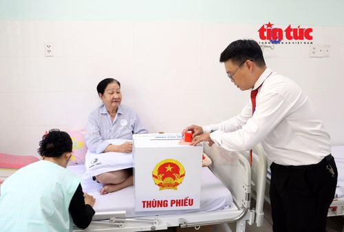 Thành viên của tổ bầu cử đóng dấu xác nhận cử tri đã bỏ phiếu bầu cử tại Bệnh viện Y học cổ truyền TP Hồ Chí Minh.