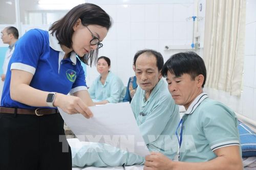 Đoàn viên thanh niên Bệnh viện Việt Đức hướng dẫn người nhà bệnh nhân và bệnh nhân về quy định bầu cử tại điểm bầu cử lưu động Bệnh viện Hữu nghị Việt Đức. Ảnh: Minh Quyết - TTXVN 