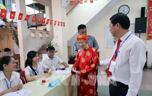 Cử tri Nguyễn Đình Tư (106 tuổi) trực tiếp bỏ phiếu tại khu vực bỏ phiếu số 11, phường Bình Thạnh, TP. Hồ Chí Minh. Ảnh: TTXVN phát 