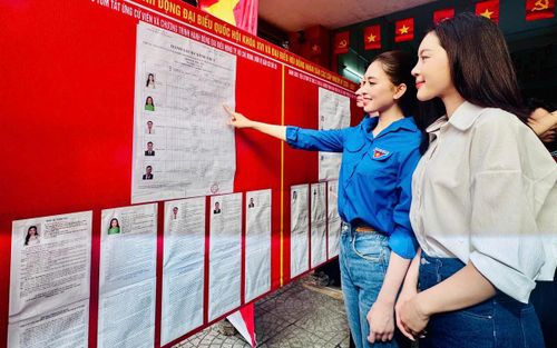 Hoa hậu Trần Tiểu Vy (áo xanh) xem tiểu sử tóm tắt của các ứng cử viên trước khi bỏ phiếu.