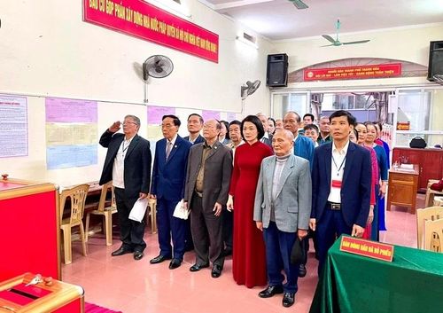 Đồng chí Đỗ Thị Toán và các cử tri thực hiện nghi thức chào cờ.