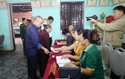 Cử tri thực hiện thủ tục nhận phiếu bầu cử.
