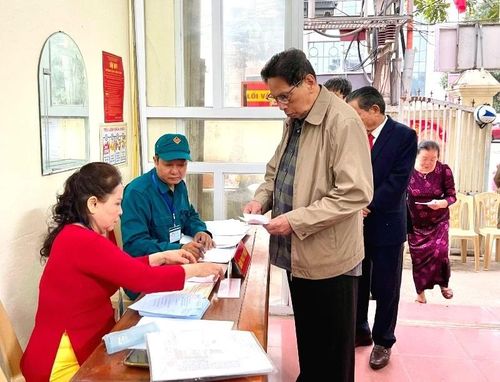 Cử tri thực hiện thủ tục nhận phiếu bầu cử.