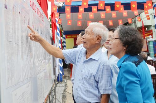 Các cử tri xem lại bảng tóm tắt tiểu sử của các ứng viên trước khi bỏ phiếu