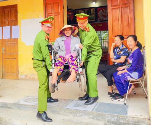  Cán bộ Công an xã Lục Nam hỗ trợ người yếu thế đi bỏ phiếu. 