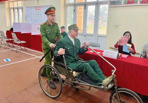  Cán bộ làm công tác bầu cử hỗ trợ thương binh đang điều dưỡng tại Trung tâm Điều dưỡng thương binh Thuận thành đến điểm bầu cử. 