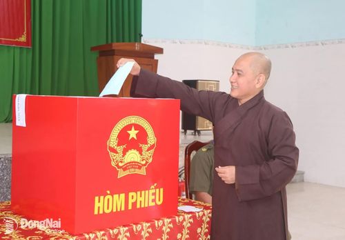 Thượng tọa Thích Pháp Đăng, Ủy viên Ban Trị sự Giáo hội Phật giáo Việt Nam tỉnh Đồng Nai, Trụ trì chùa Huệ Viễn, xã Dầu Giây là cử tri bỏ lá phiếu đầu tiên tại Khu vực bỏ phiếu số 7 (Nhà văn hóa ấp Hưng Thạnh). Ảnh: Nhật Quang