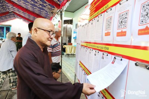 Hòa thượng Thích Minh Thọ, Phó ban Hoằng Pháp Giáo hội Phật giáo Việt Nam tỉnh Đồng Nai tìm hiểu thông tin về các ứng cử viên trước khi bỏ phiếu tại Khu vực bầu cử số 8, phường Biên Hòa. Ảnh: B.Nguyên