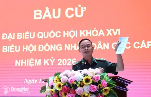 Đại tá Đào Công Lý, Tổ trưởng Tổ bầu cử số 16 - Ủy ban Bầu cử phường Đồng Xoài hướng dẫn các loại phiếu bầu cho cử tri. Ảnh: Nguyệt Hà