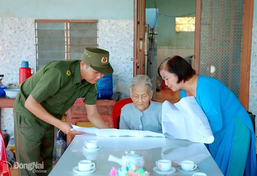 Thành viên tổ bầu cử giới thiệu các ứng cử viên đại biểu Quốc hội và đại biểu HĐND các cấp để Mẹ Việt Nam anh hùng Phạm Thị Ba chọn lựa. Ảnh: Quý Son