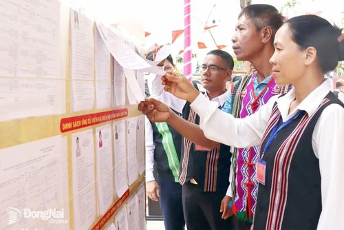 Đồng bào dân tộc thiểu số xã Bom Bo tìm hiểu tiểu sử, quá trình công tác của ứng cử viên. Ảnh: Nguyệt Hà