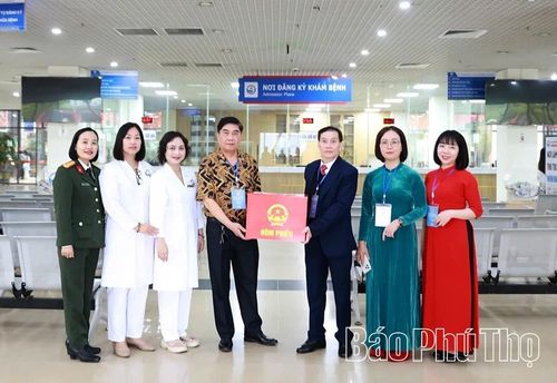 Thành viên Tổ bầu cử thuộc khu vực bỏ phiếu số 35 (Tổ dân phố 18), phường Vĩnh Phúc mang hòm phiếu phụ cho bệnh nhân đang điều trị tại Bệnh viện Đa khoa Vĩnh Phúc thực hiện quyền công dân. Ảnh: Thúy Hường