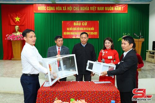 Thành viên tổ bầu cử và cử tri tiêu biểu kiểm tra hòm phiếu