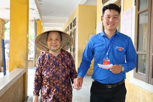  Đoàn viên, thành viên ở khu vực bầu cử số 9, xã Chân Mây - Lăng Cô hỗ trợ người già đến điểm bầu cử. Ảnh: Hữu Phúc