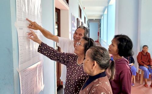  Các cử tri tại Trung tâm Công tác xã hội và Quỹ Bảo trợ trẻ em thành phố xem danh sách các ứng cử viên trước khi bầu cử. Ảnh: Hoài Thương