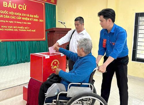 Hỗ trợ người khuyết tật ở phường Hương An bỏ phiếu. Ảnh: Đức Quang 