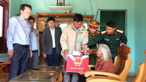 Cán bộ xã Tu Mơ Rông đem thùng phiếu đến tận nhà và hướng dẫn những người già, bệnh bầu cử tại nhà