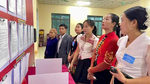 Cử tri xem danh sách và tiểu sử tóm tắt ứng cử viên trước giờ bỏ phiếu tại khu vực bỏ phiếu số 7