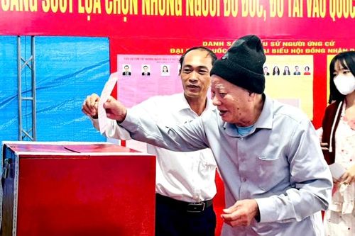Cử tri cao tuổi ở xã An Lão sức khỏe yếu phải ngồi xe lăn, nhưng vẫn nhờ sự hỗ trợ của người thân để tự mình đi bỏ phiếu. Ảnh: Nguyễn Hạnh