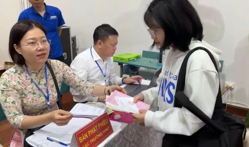 Cử tri Lê Thị Tú nhận phiếu bầu cử tại khu vực bầu cử số 23 phường Phú Diễn, Hà Nội sáng 15/3