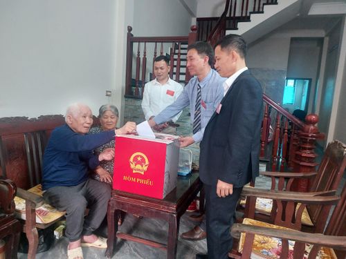 Nhiều trường hợp người cao tuổi không thể đến điểm bỏ phiếu, tổ bầu cử khu vực số 6 đã linh động thực hiện hòm phiếu di động, đến tận nhà cử tri để cử tri thực hiện bỏ phiếu. Trong ảnh là cán bộ tổ bầu cử và ông Đỗ Văn Kỳ, 92 tuổi thôn , 62 năm tuổi đảng được bỏ phiếu tại nhà do không thể đi lại. Ảnh: Trần Thu