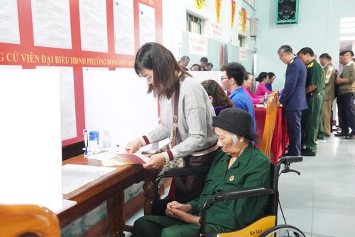 Cử tri Trần Thị Hồng được gia đình hỗ trợ thực hiện bầu cử. Ảnh: Khánh Trinh