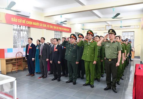 Ủy viên Ban Thường vụ Tỉnh ủy, Bí thư Đảng ủy, Chủ tịch HĐND Đặc khu Vân Đồn Cao Tường Huy cùng các cử tri dự lễ chào cờ trước khi bầu cử.