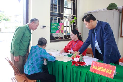 Ông Từ Ngọc Thành, Chủ tịch UBND xã Chương Dương, hướng dẫn người dân tại khu vực bỏ phiếu.