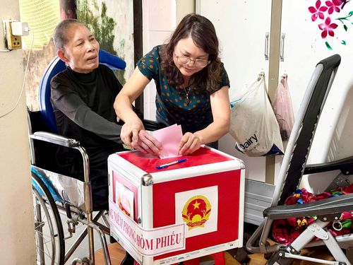 Con gái ông Nguyễn Văn Dũng giúp mẹ bỏ phiếu. Ảnh: Vân Nga