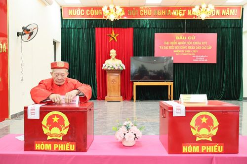 Ông Đặng Đức Minh (82 tuổi) là người bỏ phiếu đầu tiên tại khu vực bỏ phiếu số 10. Ảnh: Phương Ngân